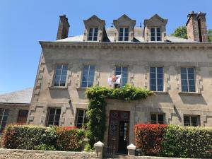 uma casa velha com uma bandeira na porta em Au Fil du Temps em Mallièvre