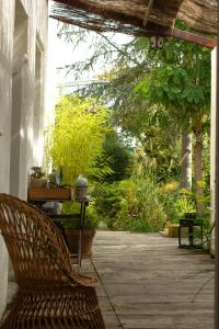 um alpendre com um banco, uma mesa e árvores em MAISON MATEJEWSKI chambre d'hôtes avec jardin em Blaye