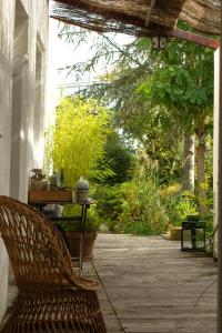 a porch with a bench and a table and trees at MAISON MATEJEWSKI chambre d'hôtes avec jardin in Blaye