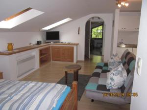 een slaapkamer met een bed en een keuken met een tv bij Raffaela Maderspacher in Oberammergau