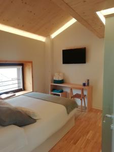 a bedroom with a bed and a desk and a television at Hotel Rural Aguazul in Covanera