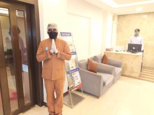 a man wearing a gas mask standing in a lobby at Hotel Ashok Residency in Chennai