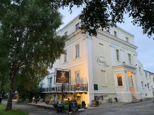 a white building with a sign in front of it at Clarence Court Hotel in Cheltenham