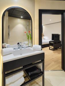 a bathroom with a sink and a large mirror at H10 Puerta de Alcalá in Madrid