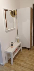 een witte tafel met een spiegel aan een muur bij Corso Nobile Apartament in Płock