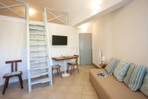a living room with a couch and a desk and a ladder at Santorini Med Homes - Sunday Apartment in Mesaria
