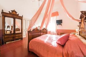 1 dormitorio con cama con dosel y vestidor en Villa Mariella Pittorino - camere in B&B, en Leni