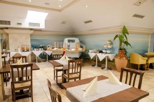 a restaurant with tables and chairs and a boat in the background at Hotel du Faucon in Fribourg