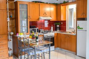 a kitchen with wooden cabinets and a table with chairs at Sofi - Stavros Studio in Agalianós