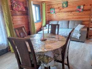 a dining room with a table and chairs and a couch at CASAMELIAS Le chalet in Cilaos