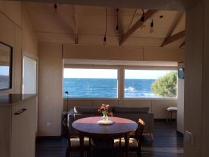 een woonkamer met een tafel en uitzicht op de oceaan bij Nouvelle Vague in Bretteville