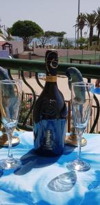 a bottle of wine sitting on a table with two glasses at PLAYA LAS VISTAS LOFT in Los Cristianos