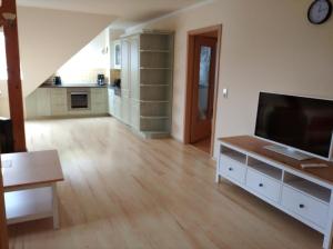 ein Wohnzimmer mit einem Flachbild-TV und eine Küche in der Unterkunft Apartments SMAG Obere Burgstraße in Pirna