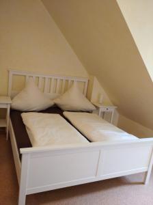 ein weißes Bett mit weißen Kissen in einem Zimmer in der Unterkunft Apartments SMAG Obere Burgstraße in Pirna