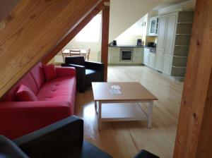 ein Wohnzimmer mit einem roten Sofa und einem Tisch in der Unterkunft Apartments SMAG Obere Burgstraße in Pirna
