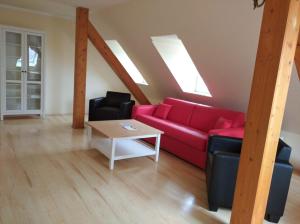 ein Wohnzimmer mit einem roten Sofa und einem Tisch in der Unterkunft Apartments SMAG Obere Burgstraße in Pirna