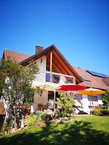 ein Haus mit zwei Sonnenschirmen im Hof in der Unterkunft Ferienwohnung Suedbalkon in Friesenheim