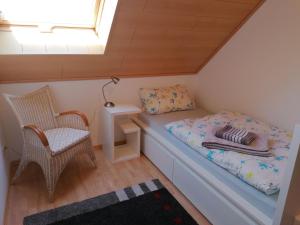 a small bedroom with a bed and a chair at Ferienwohnung Suedbalkon in Friesenheim