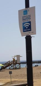 a free wifi sign on a pole at the beach at PLAYA LAS VISTAS LOFT in Los Cristianos