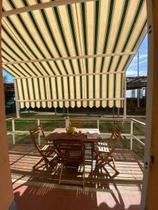 a patio with a table and chairs under awning at Residence Riviera in Albenga