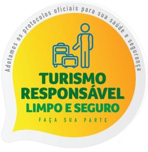 een sticker van een man met bagage in een gele cirkel bij Hotel Green Hill in Juiz de Fora