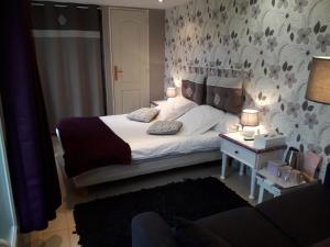 a bedroom with a bed and a table with lamps at Les Trois Pommiers in Sommery