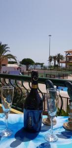 a bottle of wine sitting on a table with two glasses at PLAYA LAS VISTAS LOFT in Los Cristianos