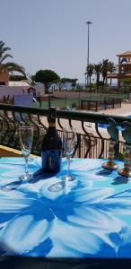 a table with two wine glasses and a bottle on it at PLAYA LAS VISTAS LOFT in Los Cristianos