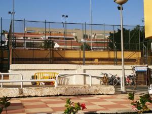 a fence with bikes parked in front of a train at PLAYA LAS VISTAS LOFT in Los Cristianos
