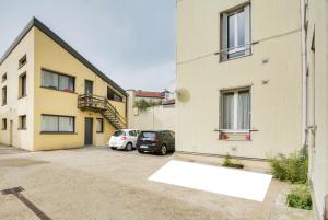 Un edificio con dos coches estacionados en un estacionamiento. en L'indépendant de la rue du Tapis Vert - Appt Nancy, en Nancy