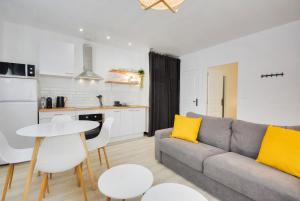 Una sala de estar con un sofá y una mesa con cojines amarillos. en L'indépendant de la rue du Tapis Vert - Appt Nancy, en Nancy 10 fotos más