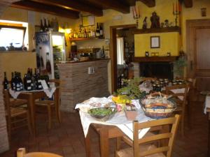 a dining room with a table and chairs and a kitchen at Agriturismo Le Vergare in Offagna