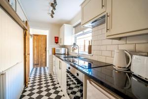 uma cozinha com piso em xadrez preto e branco em Victoria Cottage em York