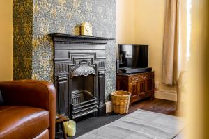 a living room with a fireplace and a television at Victoria Cottage in York