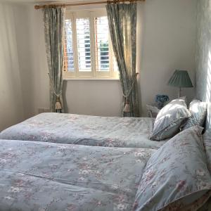 a bedroom with two beds and a window at Brook Lodge Country Cottage in Doncaster