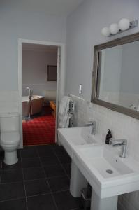 a bathroom with two sinks and a toilet and a tub at Boat Country Inn and Restaurant in Boat of Garten