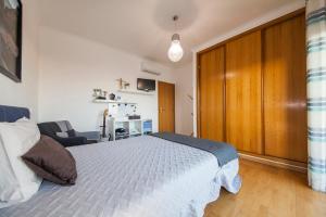 a bedroom with a white bed and a wooden door at D09 - Porto de Mós Luxury Villa in Lagos