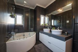 a bathroom with two sinks and a bath tub and a tubermott at D09 - Porto de Mós Luxury Villa in Lagos