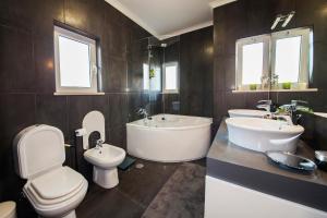 a bathroom with two sinks and a tub and a toilet at D09 - Porto de Mós Luxury Villa in Lagos