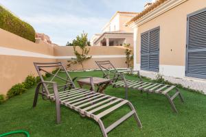a group of chairs sitting on top of a yard at D09 - Porto de Mós Luxury Villa in Lagos