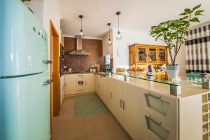 a kitchen with white cabinets and a refrigerator at D09 - Porto de Mós Luxury Villa in Lagos