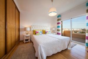 a bedroom with a white bed and a large window at D09 - Porto de Mós Luxury Villa in Lagos