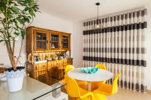 a dining room with a table and yellow chairs at D09 - Porto de Mós Luxury Villa in Lagos
