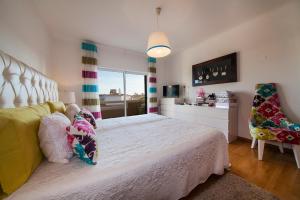 a bedroom with a white bed and a chair at D09 - Porto de Mós Luxury Villa in Lagos