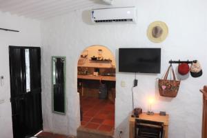 uma sala de estar com televisão numa parede branca em Casa de Piedra Taganga em Taganga