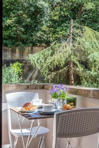 tavolo e sedie con cibo e fiori di Cozy Roman Apartment with parking a Firenze