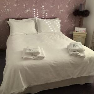 a white bed with two towels on top of it at Brook Lodge Country Cottage in Doncaster