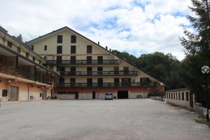 a large building with a parking lot in front of it at Sport & Relax Roccaraso in Roccaraso