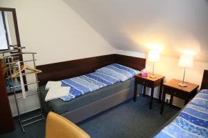 1 dormitorio con 1 cama y 2 mesas con lámparas en Pension & Restaurace Na Rychtě, en Praga