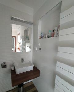 bagno bianco con lavandino e specchio di Lilla Villa a Siófok